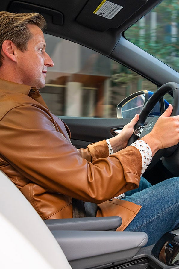 A shot of a man sitting in driver’s seat of an ID.4 with both hands on the steering wheel.